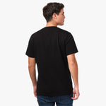 Back view of a man wearing the black t-shirt: The man is standing with his back to the camera, showing the simple back design of the t-shirt.