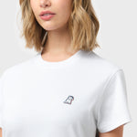 Close-up of the woman's chest area showing the small embroidered logo on the front of the white t-shirt.