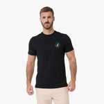 A man wearing a black T-shirt with a small circular logo on the left chest