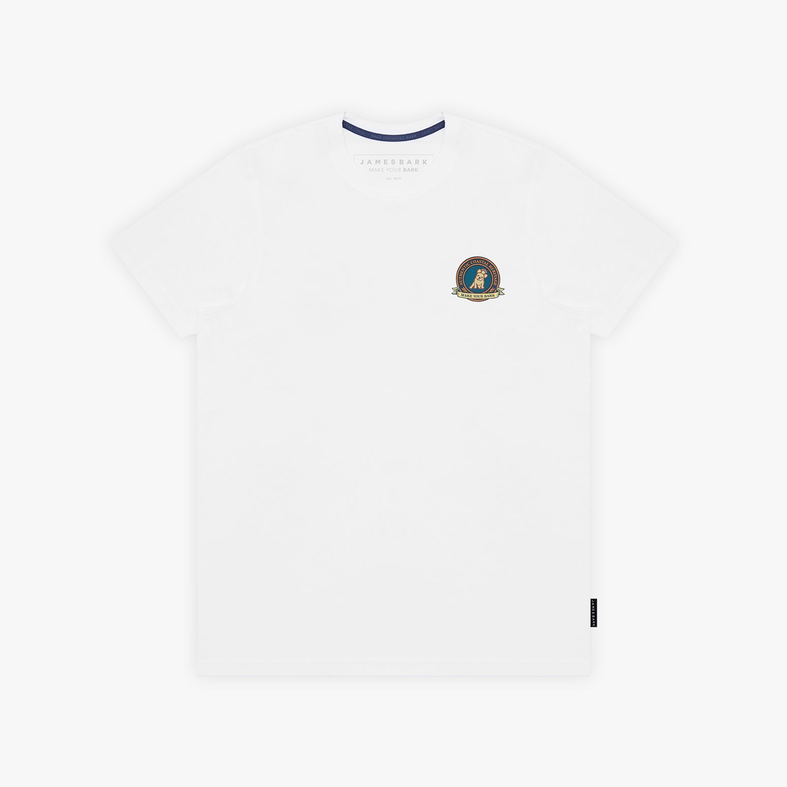 A white T-shirt with a small circular crest printed on the left chest. The inner collar features a contrasting navy blue trim, and a small black tag is visible near the bottom-right hem.