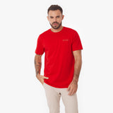 Male model wearing a red James Bark t-shirt with embossed logo patch, waist up