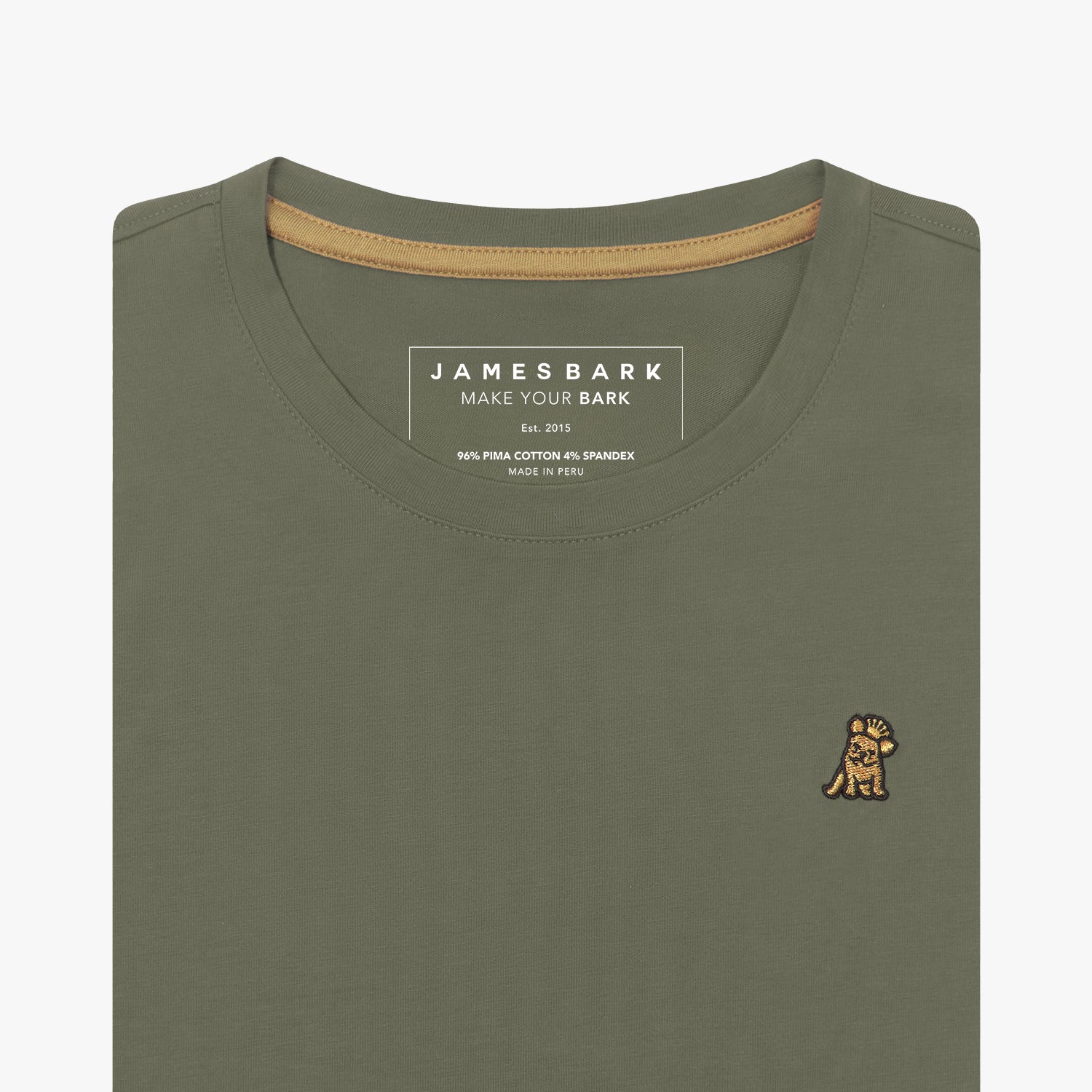 Detailed close-up view of an olive green women's crew neck t-shirt. Shows the printed internal brand tag "JAMES BARK", contrasting gold neck tape, and the gold/yellow embroidered dog logo just below the neckline on the left chest