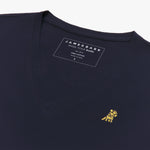 Angled close-up of the navy blue v-neck t-shirt's neckline and chest, highlighting the inner printed label and the detailed yellow and black embroidered dog logo