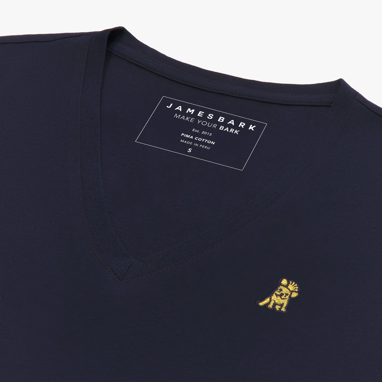 Angled close-up of the navy blue v-neck t-shirt's neckline and chest, highlighting the inner printed label and the detailed yellow and black embroidered dog logo