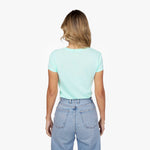 Back waist-up view of a female model wearing a plain mint green short-sleeve t-shirt and light wash jeans