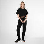 Full-length shot of a woman modeling a black James Bark Elements cropped t-shirt and joggers set.