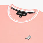 Close-up of the neckline and small dog graphic on the chest of the light pink T-shirt with white trim.