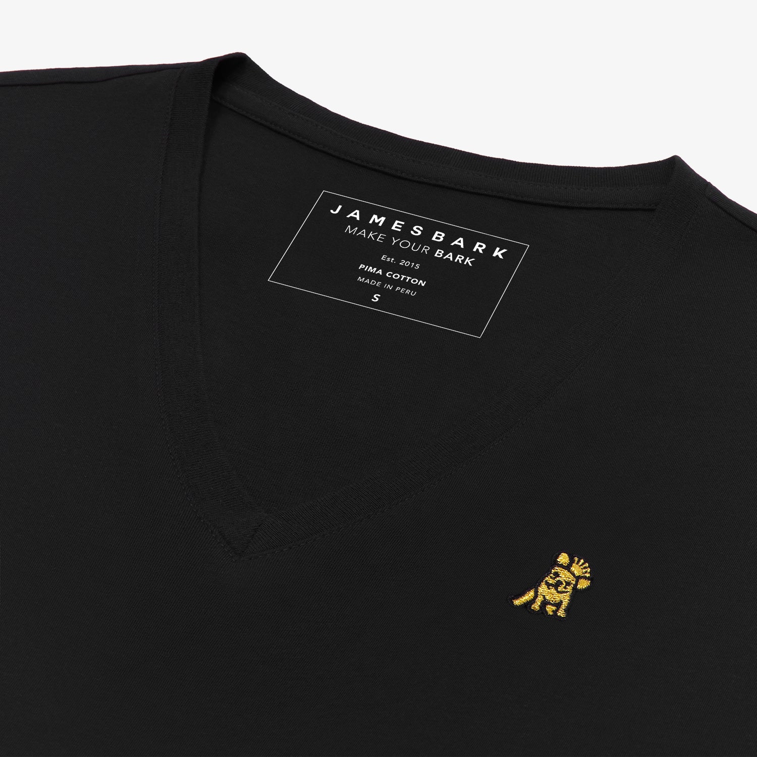 Angled close-up of the black v-neck t-shirt's neckline and chest, highlighting the inner printed label and the detailed yellow and black embroidered dog logo