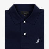 Close-up of the collar and upper part of the navy blue polo shirt, showing the buttons and the small embroidered logo on the chest.