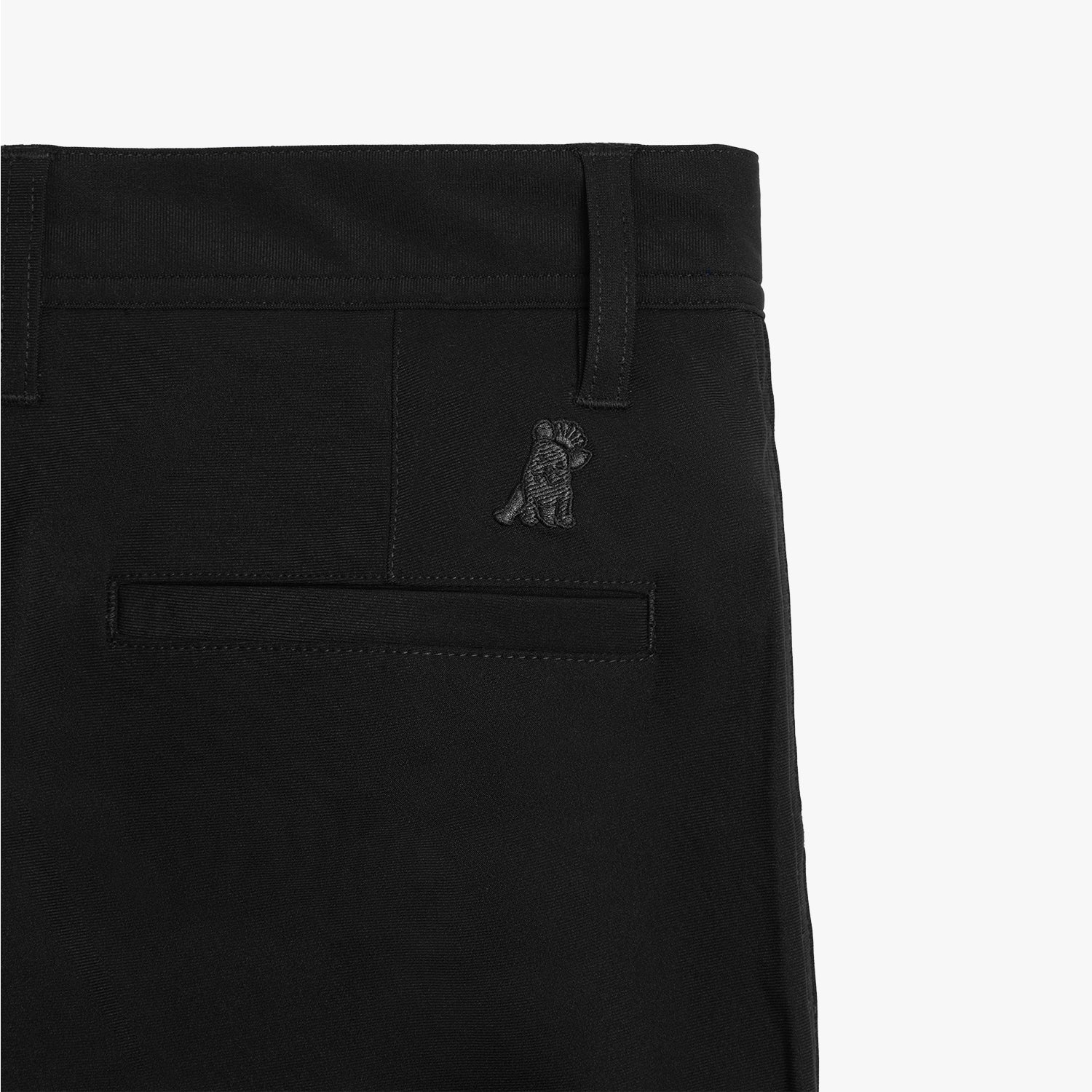 A detailed close-up of the pocket stitching and subtle embroidered logo on the black pants.