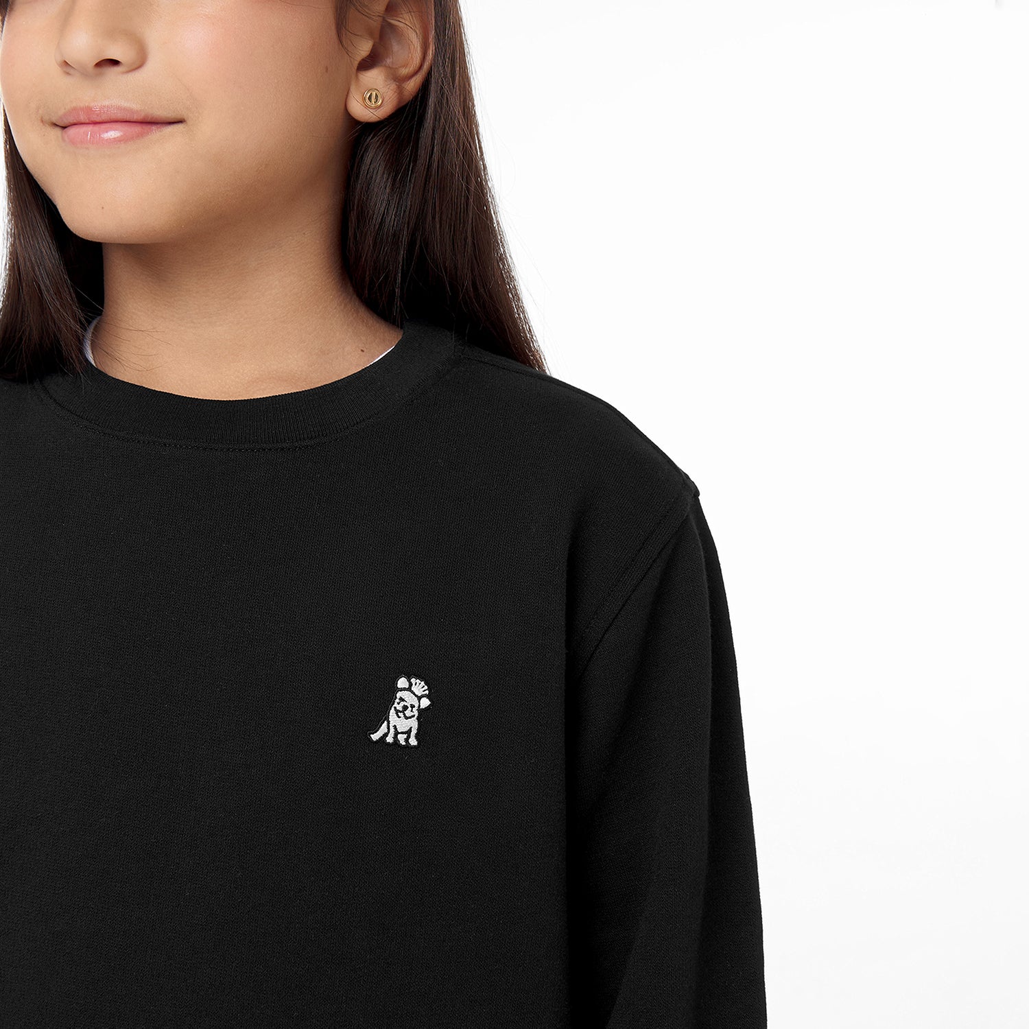 Close-up side view of the black sweatshirt worn by a child, focusing on the chest area with the embroidered dog logo.