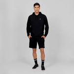 
This image shows a sporty, casual look with a black hoodie and matching black shorts, complete with the signature logo on both the hoodie and the shorts. The look is complemented by high socks and black sneakers, making it a great option for an athletic or streetwear-inspired outfit.