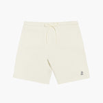 Flat-lay front view of cream-colored shorts featuring a drawstring waistband and a small embroidered dog logo near the hem