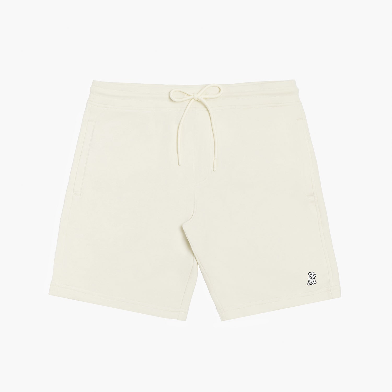 Flat-lay front view of cream-colored shorts featuring a drawstring waistband and a small embroidered dog logo near the hem