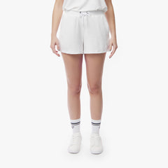 Front view of a model wearing white shorts with a drawstring waistband, styled with white sneakers and striped socks, standing against a white background