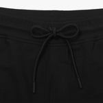 This close-up image shows the waistband of the black shorts, highlighting the drawstring tie. The drawstring is black, matching the color of the shorts, and has tipped ends. This adds to the overall simple and clean aesthetic of the shorts