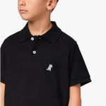 Close-up of the chest area of the black polo shirt, featuring the small embroidered logo.