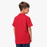 Rear view of the boy wearing the red polo shirt, showing the plain back design.