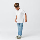 Full-body shot of the boy wearing the white polo shirt and jeans, looking down and standing casually.