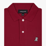  Close-up of the collar and upper part of the red polo shirt, showing the buttons and the small golden embroidered logo on the chest.