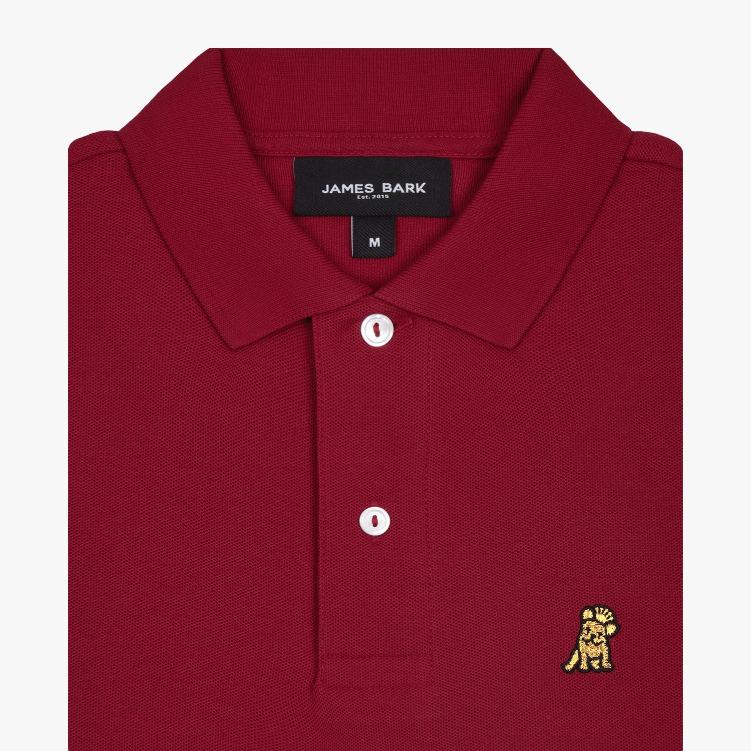 Close-up of the collar and upper part of the red polo shirt, showing the buttons and the small golden embroidered logo on the chest.