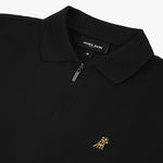 Flat lay of the black polo shirt with a gold embroidered logo on the left chest.