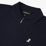 Flat lay of the navy blue polo shirt, showing the logo on the left chest and the zipper design