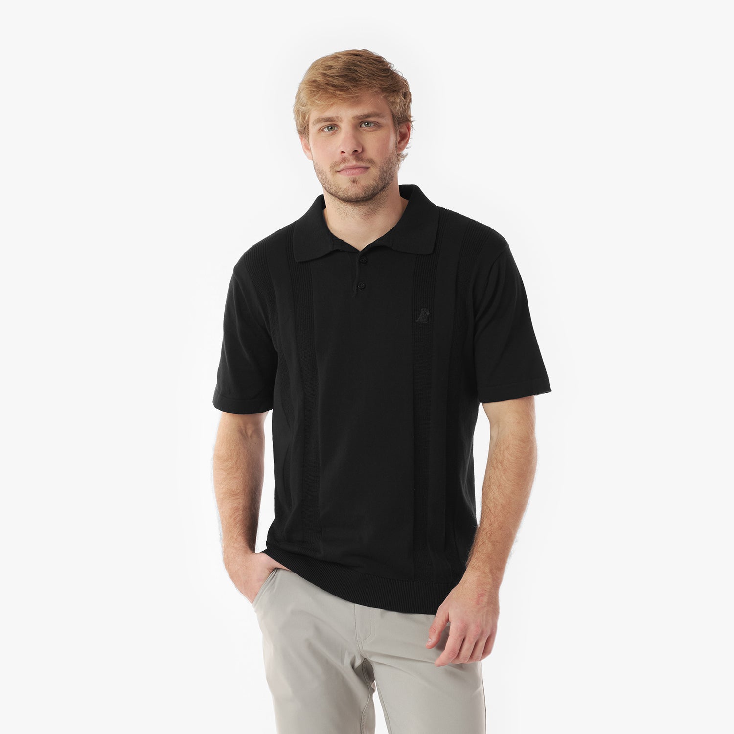 Man wearing a black polo shirt and light gray pants on a white background