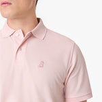 Close-up of a pink polo shirt showing the collar, buttons, and light pink embroidered dog logo