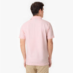 Back view of a male model wearing a pink polo shirt and light grey pants
