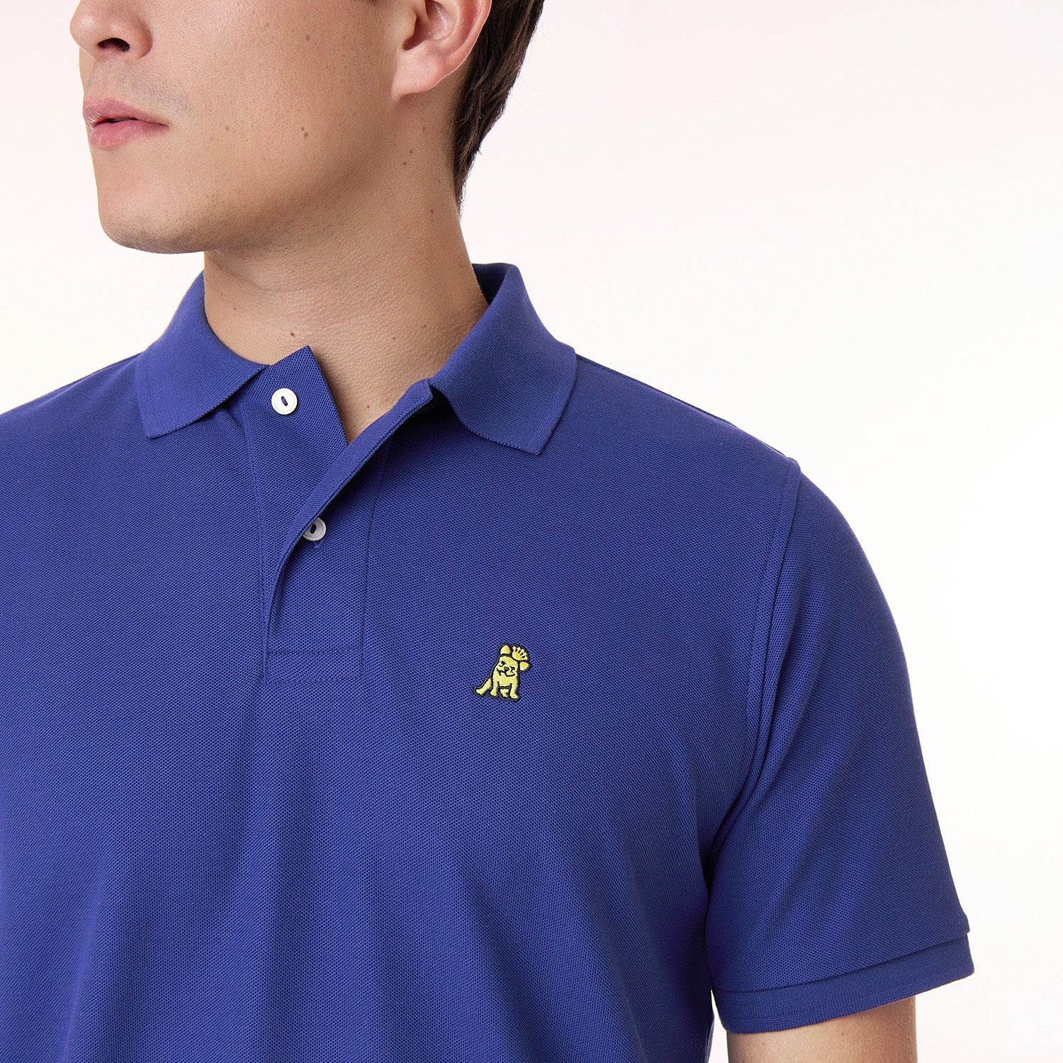 A cropped view of the upper chest of the model wearing the shirt, focusing on the collar and James Bark’s signature embroidered logo
