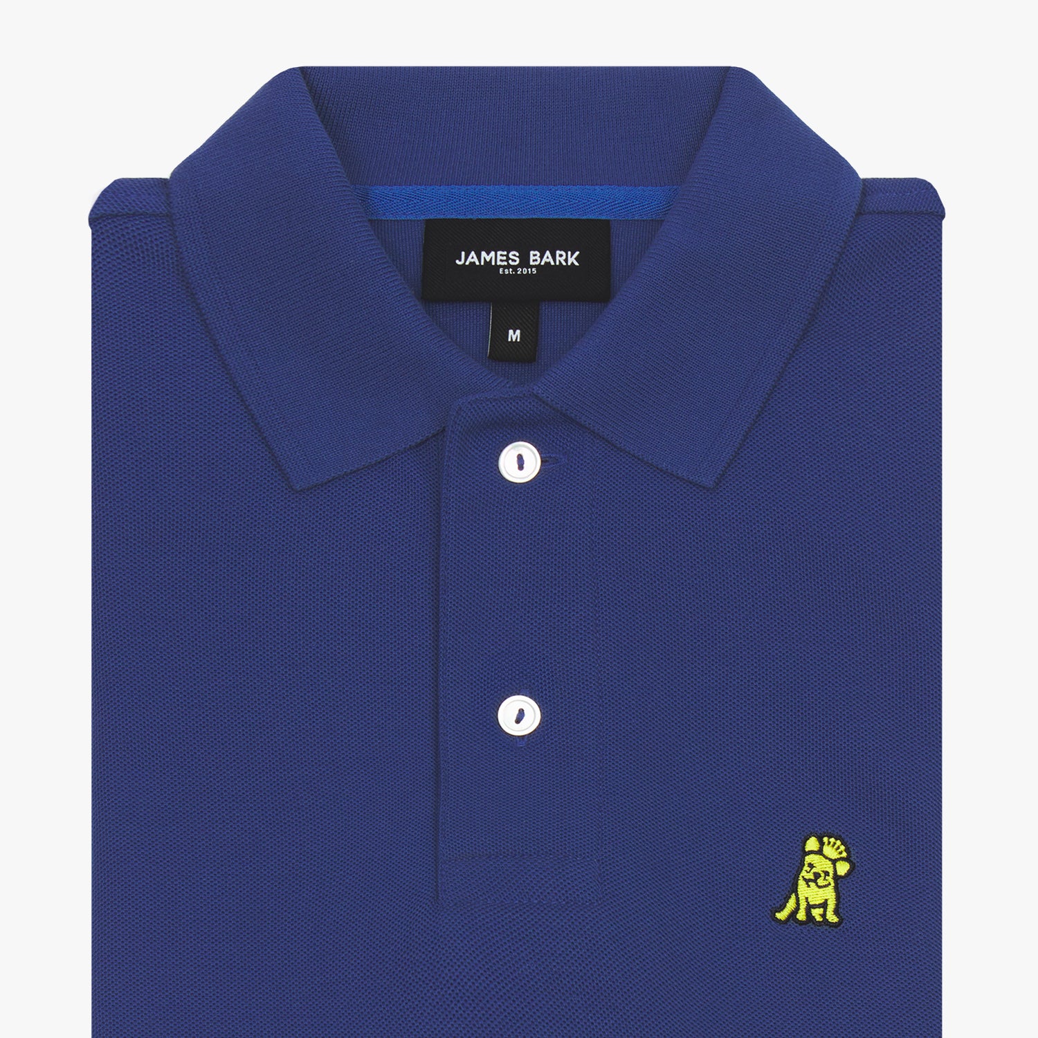 A folded detail of the polo shirt’s collar and buttons, zoomed in to showcase the embroidery and fabric quality