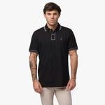 Male model wearing a black short-sleeve polo shirt with contrasting gray details on the collar, button placket, and sleeve cuffs. The polo features a subtle embroidered logo on the chest. Paired with beige trousers for a modern and sophisticated look.