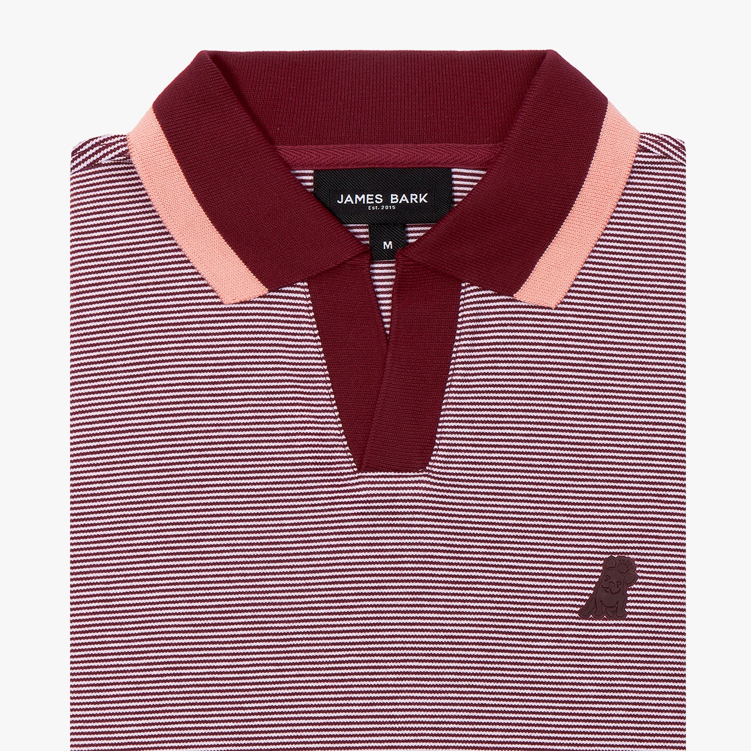 A close-up of a striped polo shirt with a fine burgundy and white micro-stripe pattern. The ribbed collar is deep burgundy with a contrasting pink stripe along the edges, adding a refined touch. The placket is open, maintaining a modern, relaxed style. A small, embossed tonal dog logo is subtly placed on the left chest for a minimalist yet sophisticated detail. The fabric appears textured and breathable, ideal for casual yet polished looks.