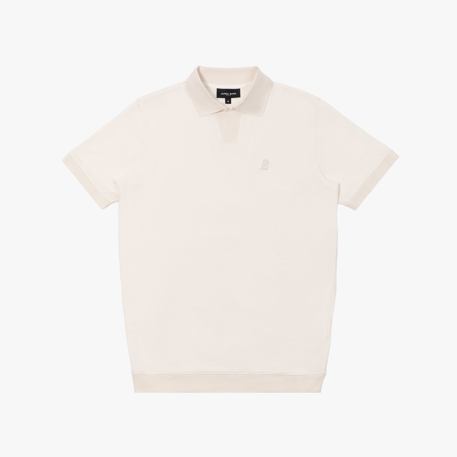 A cream-colored polo shirt laid flat on a white background. It features a ribbed collar and sleeve cuffs in a slightly darker shade, along with a short V-neck opening. A small embroidered logo of a dog in a subtle tone-on-tone thread is positioned on the left chest area. The neckline includes a black label with white text displaying the brand "JAMES BARK." The fabric appears soft and breathable.