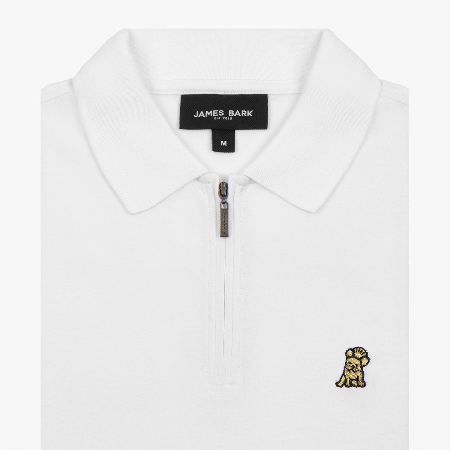 Close-up view of the collar and zipper of the white polo shirt, featuring a gold embroidered logo.