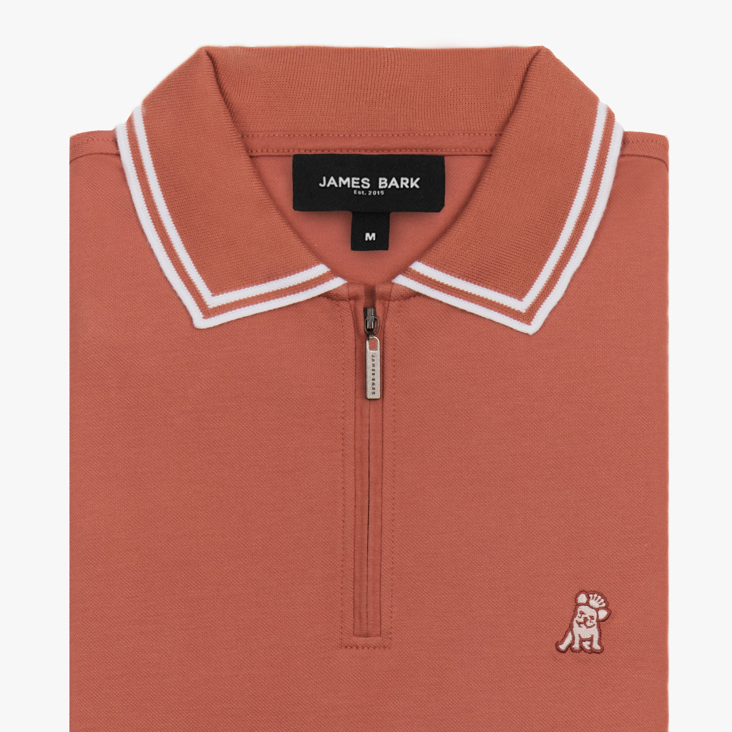 Flat lay of a rust-colored polo shirt with white trim on the collar and sleeves