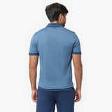 Rear view of a male model wearing a blue short-sleeve polo shirt. The polo features a classic collar, ribbed sleeve cuffs, and a smooth, fitted design. Paired with matching blue trousers