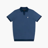 A navy blue polo shirt from "JAMES BARK" with a contrasting darker blue ribbed collar and sleeve cuffs. The shirt features a V-neck opening without buttons, giving it a modern and sleek look. A small white embroidered dog logo is placed on the left chest. The fabric appears textured, and the hem is finished with a matching dark blue ribbed band for a refined touch.