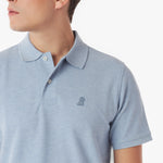 Close-up of a light blue polo shirt with a small logo on a white background