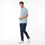 Full body picture of a man wearing a light blue polo shirt and navy pants on a white background