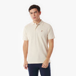 Man wearing a beige polo shirt with a logo on a white background