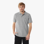 Man wearing a gray polo shirt with a small logo on a white background