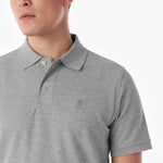 Close-up of a gray polo shirt with a small logo on a white background
