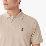 Close-up of a beige polo shirt with a small logo on a white background