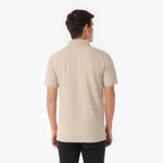 Back picture of a man wearing a beige polo shirt on a white background