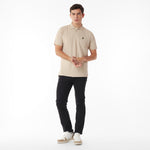 Full body picture of a man wearing a beige polo shirt and black pants on a white background