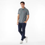 Full body picture of a man wearing a gray polo shirt with a red logo and navy pants on a white background
