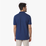 Back view of a man wearing a blue polo shirt on a white background