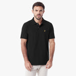 A man wearing a black short-sleeve polo shirt with a small gold embroidered logo on the left chest